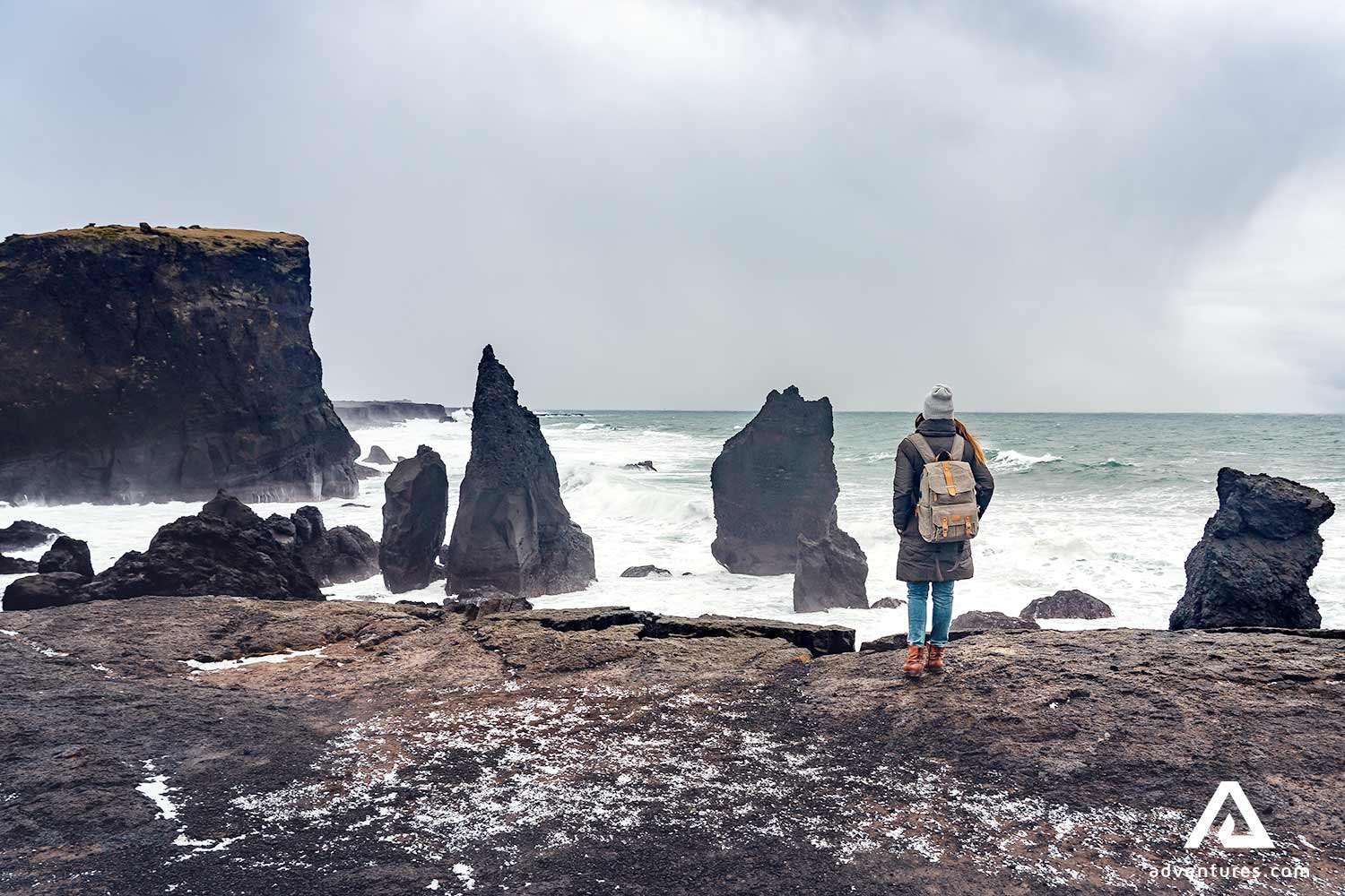 woman walking near sea stacks in reykjanes in iceland