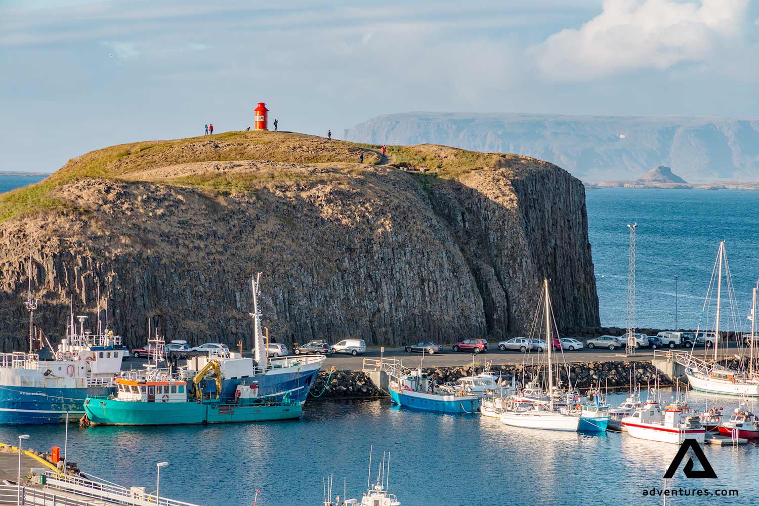 boats docked at stykkisholmur near a cliff
