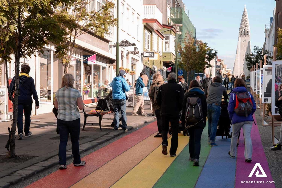 people walking down a rainbow painted road