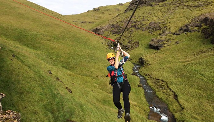 happy woman going down a zipline on a tour