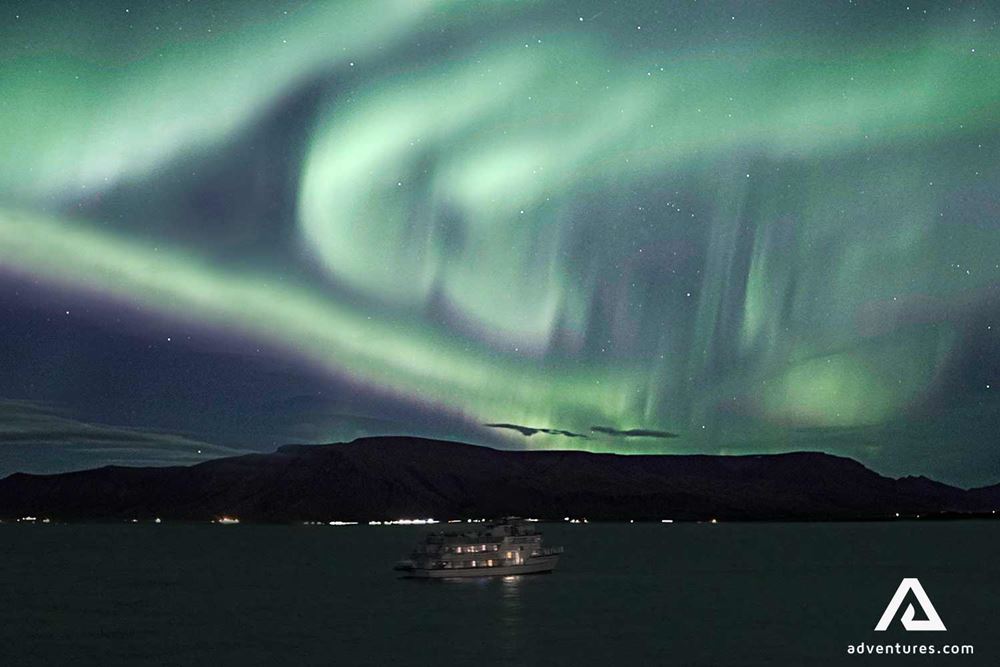 northern lights above a boat near reykjavik