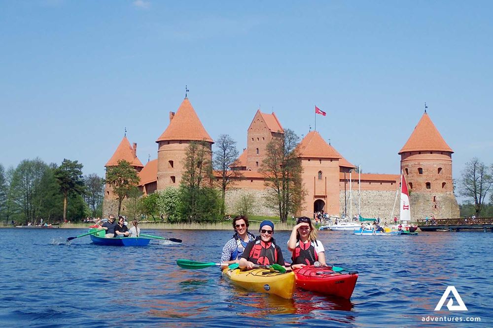 happy group kayaking near trakai castle
