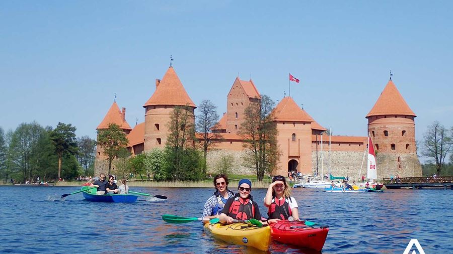 happy group kayaking near trakai castle