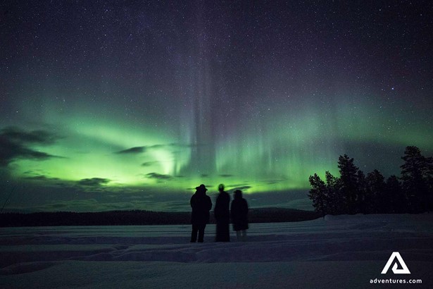 shilloutte of people watching nothern lights in sweden