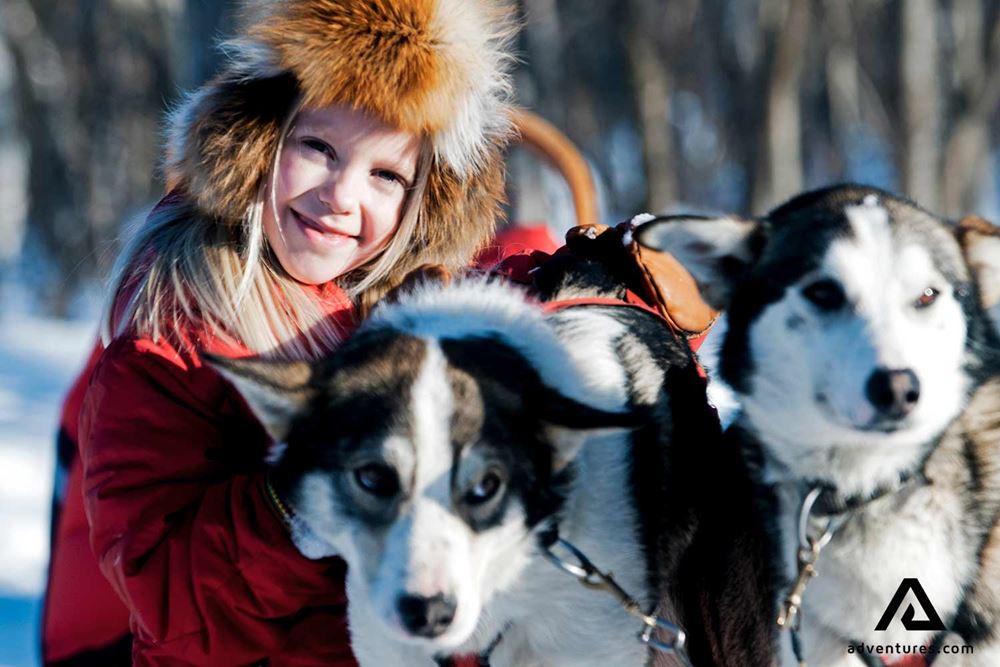 happy girl near snow dogs