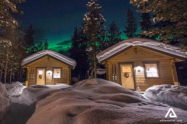 wooden cabins with northern lights in lapland