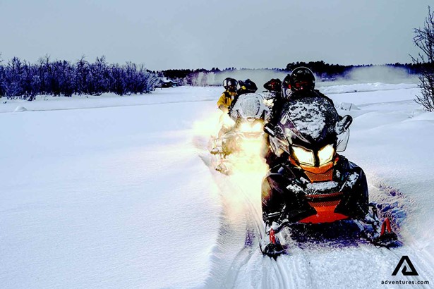 small group snowmobiling in the evening