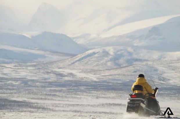 snowmobiling near snowy mountains snowmobiling near snowy mountains in sweden