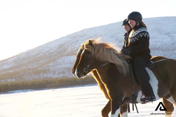 two women horse riding in winter