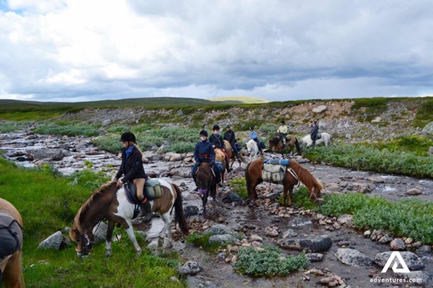 horse riding and crossing a small river on ratekjokk trail