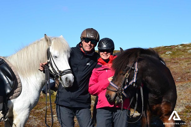 couple posing near horses in sweden
