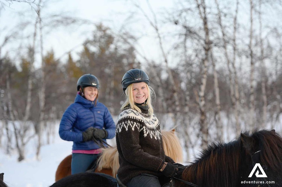 two happy woman smiling on horses in sweden