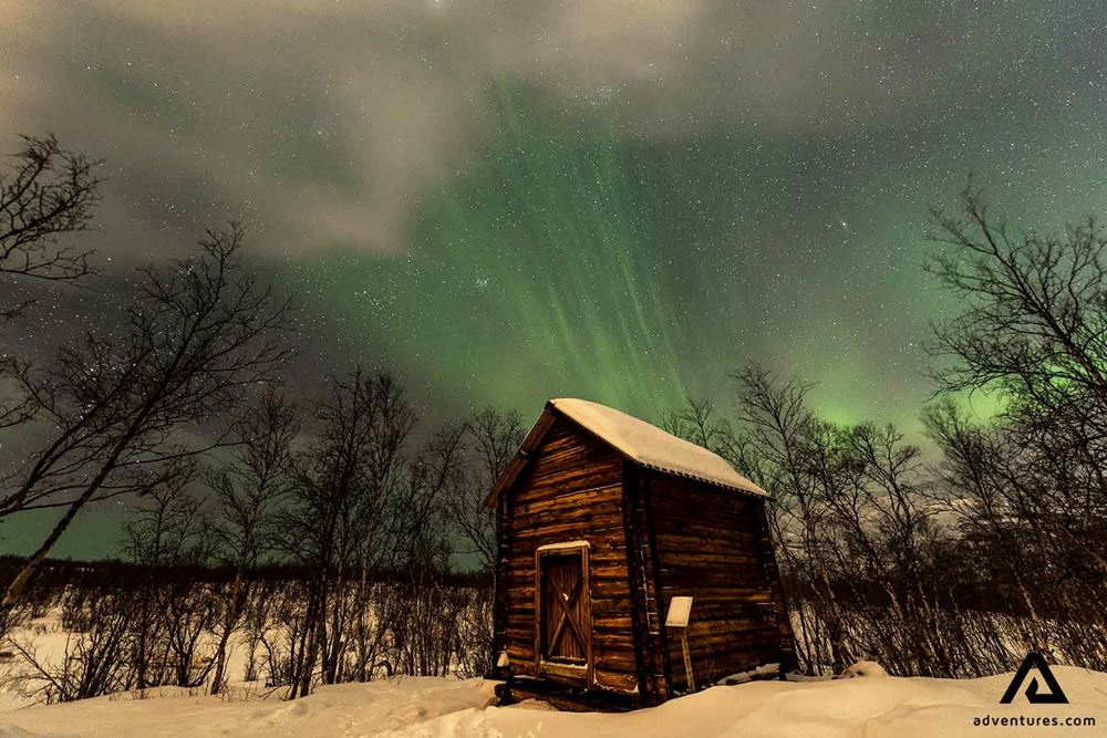small wooden cabin in a winter field