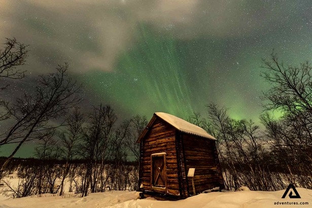 small wooden cabin in a winter field in sweden