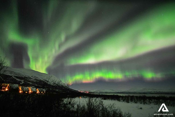 northern lights above a town in sweden lapland at winter