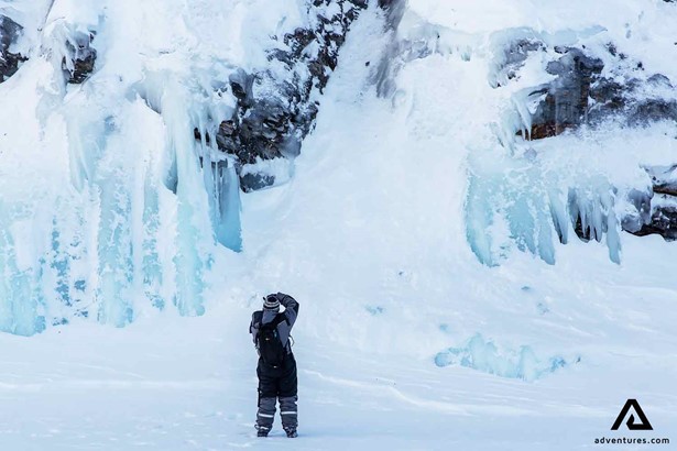 taking pictures of a frozen waterfall in lapland