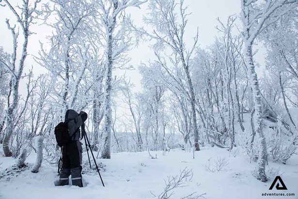 photographer in a snowy field in abisko lapland