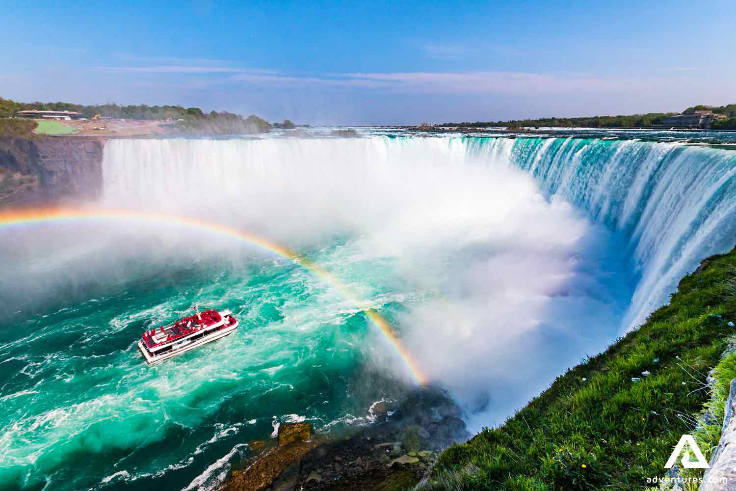 rainbow over niagara falls and a sightseeing boat