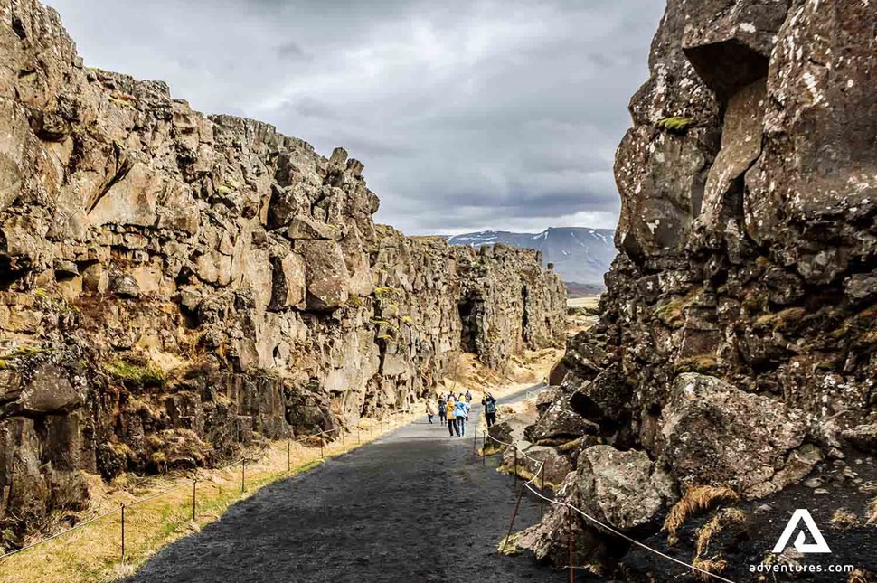 people walking between continental plates in thingvellir national park
