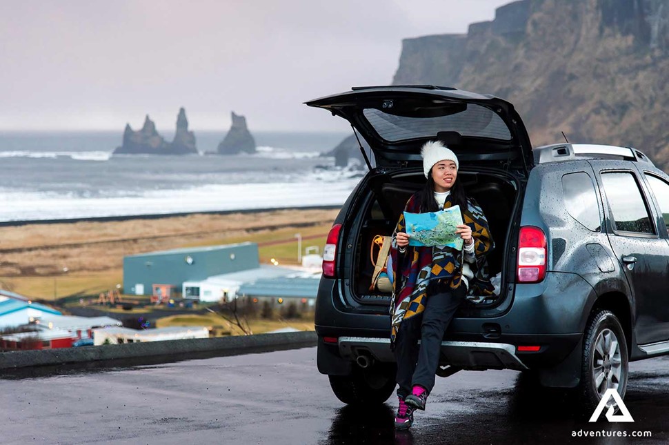 woman looking at a map near vik town in iceland