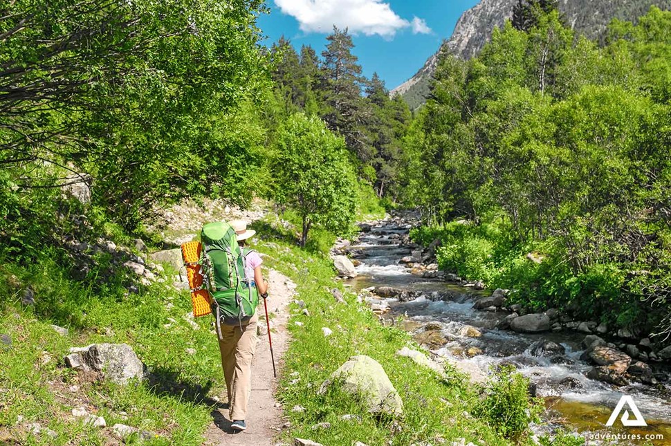 trekking in summer near a river and a forest