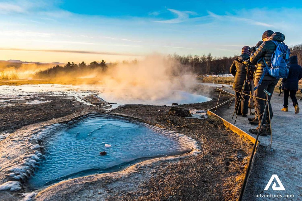 people walking around geysir geothermal area