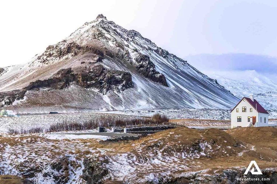 house in arnarstapi near mountains in winter