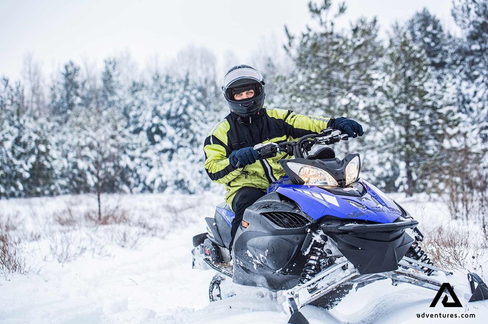 snowmobiling in a snowy forest at winter