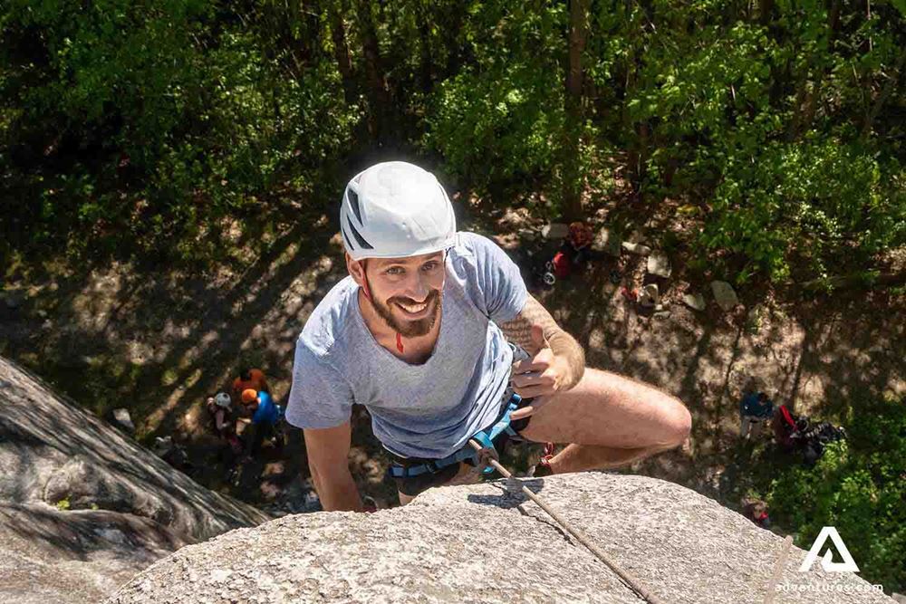 smiling man rock climbing