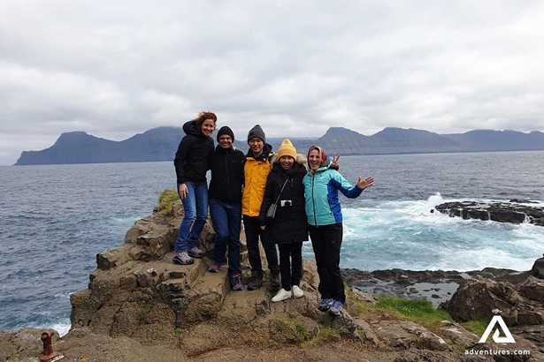 happy group near oceanside in faroe islands