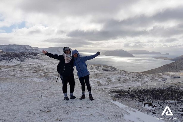 two happy women hiking in winter in faroe islands