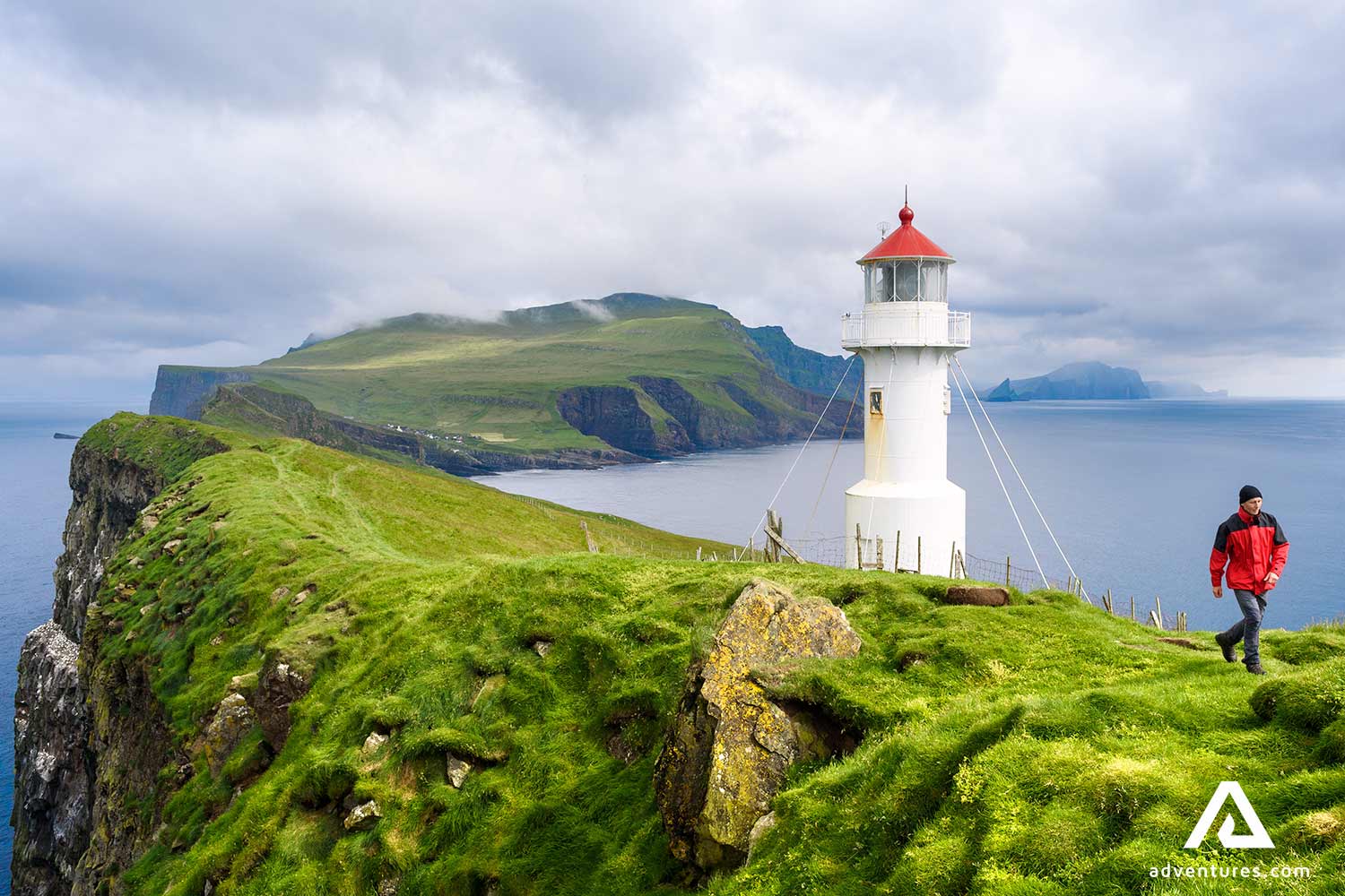 man walking near mykines lighthouse in faroe islands