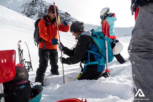 guide helping a skier in canada