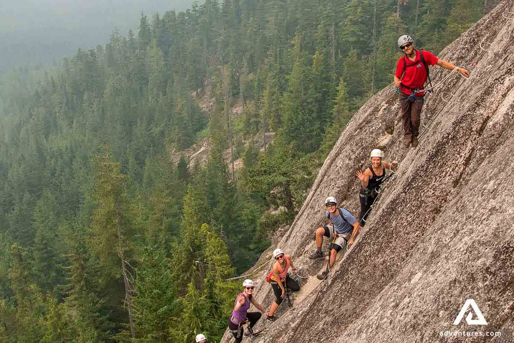 group climbing a steep cliff