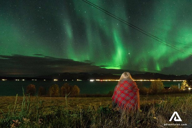 woman watching aurora borealis in norway at night