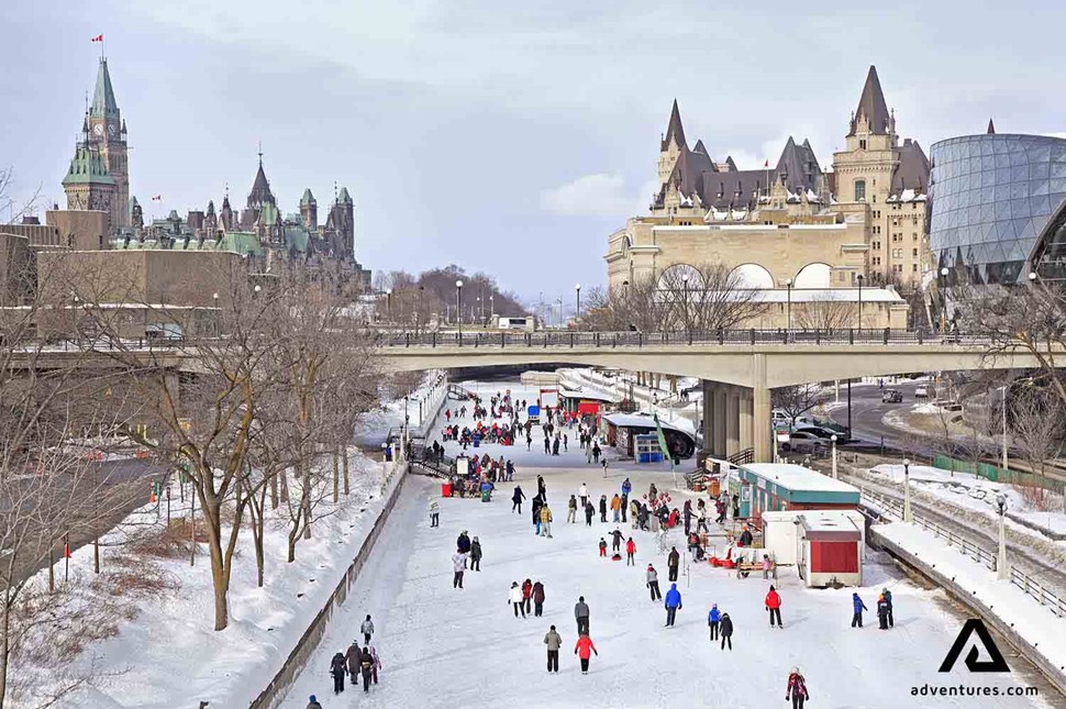 people ice skating on a frozen river canal in canada