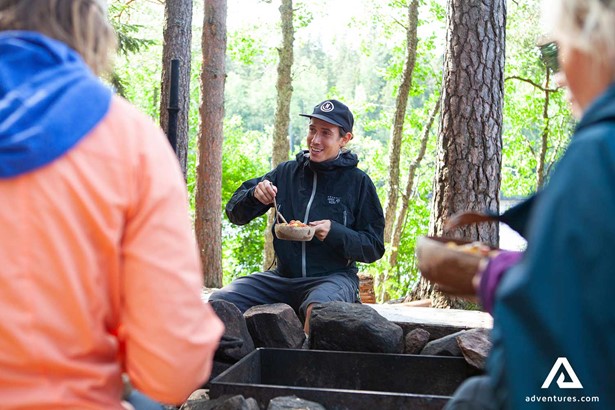 guide telling stories and eating food in a campsite