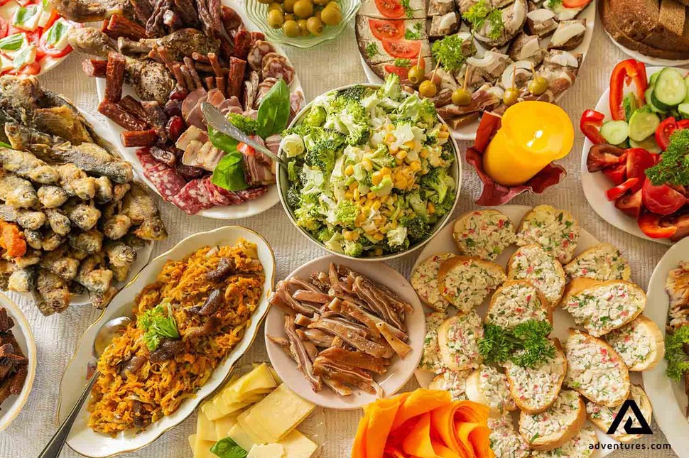 a table full of different lithuanian dishes and salads