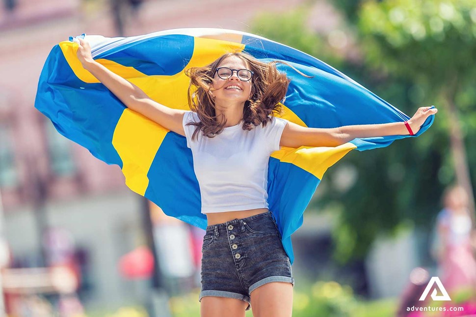 happy girl running with swedish flag in stockholm