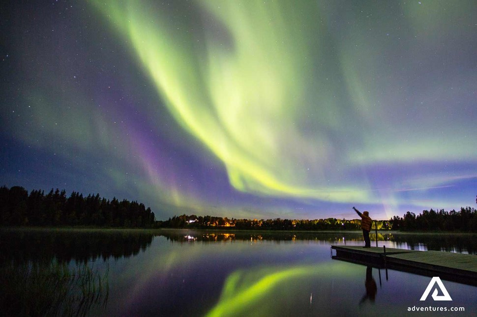 watching northern lights near a lake in winter