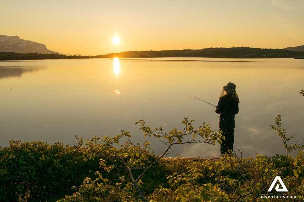 man fishing at a lake in sweden at sunset