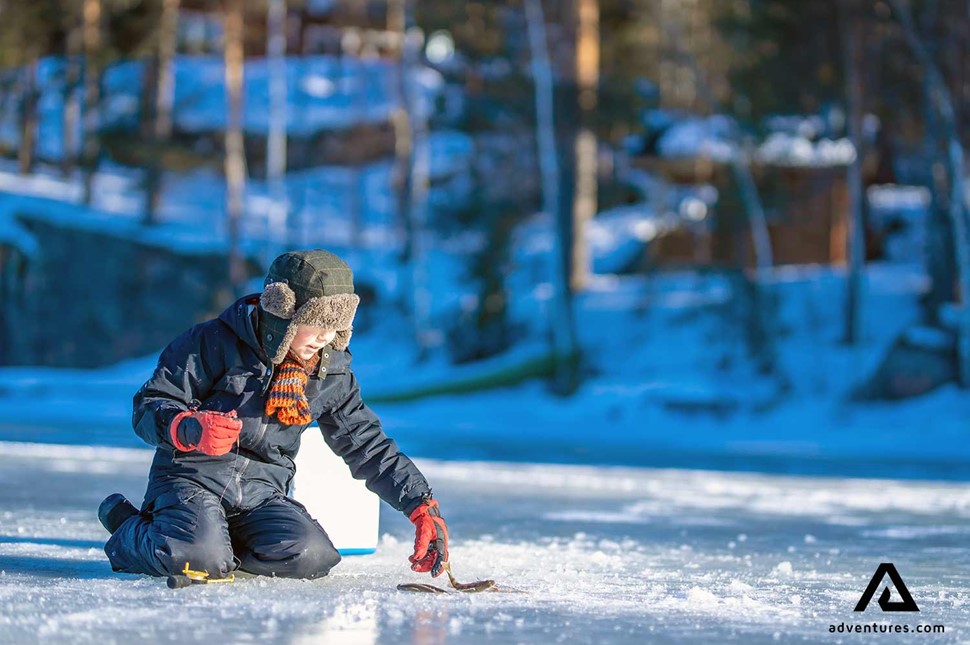 young boy fishing on a frozen lake in sweden