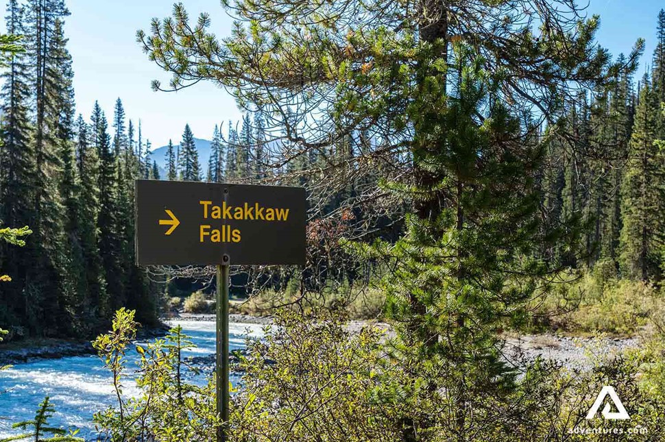 a sign pointing towards takakkaw falls in winter