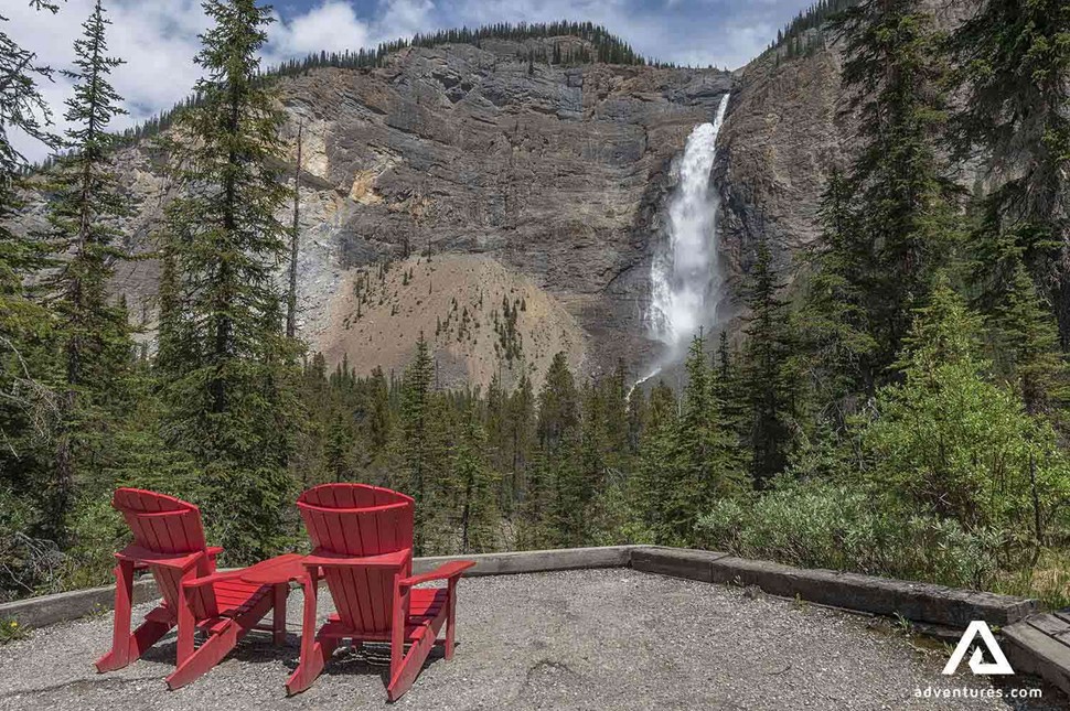 two red wooden chairs near Takakkaw falls in canada