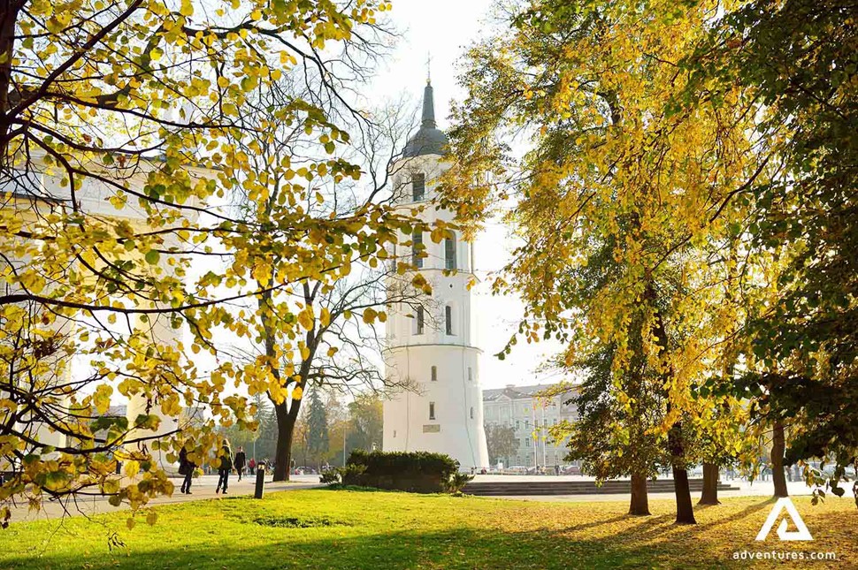 vilnius cathedral clocktowers behind trees in autumn