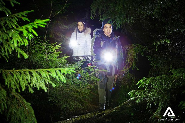 hikers exploring a forest with flashlights