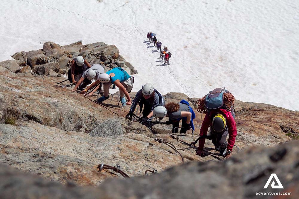 group climbing a cliff