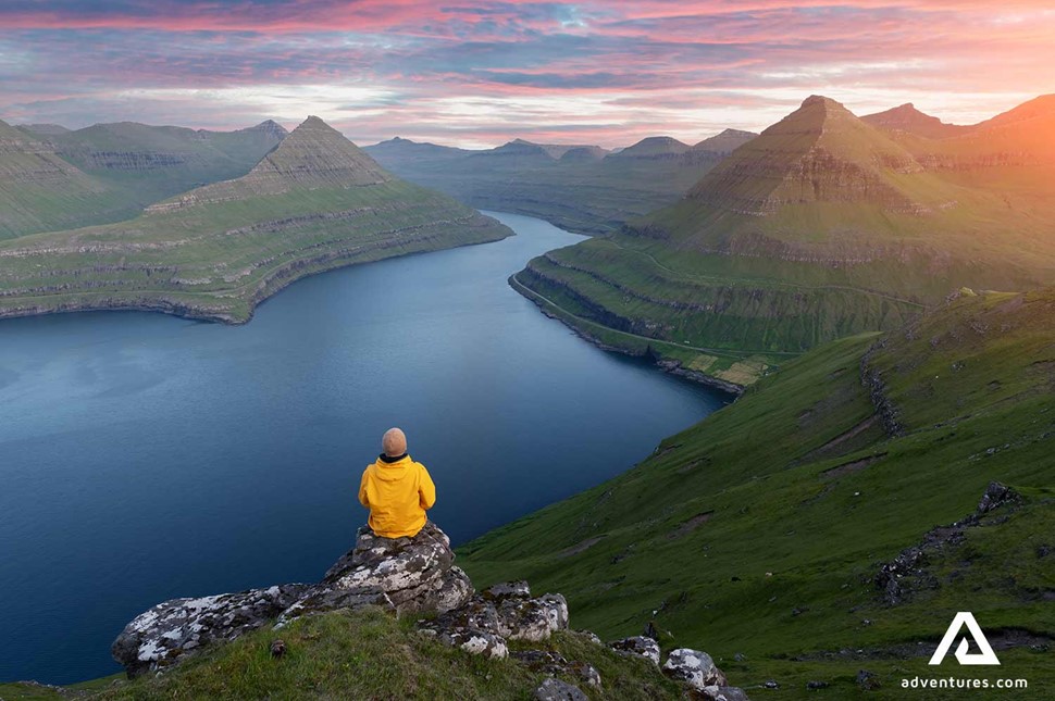 sitting on a mountain top in faroe islands at sunset