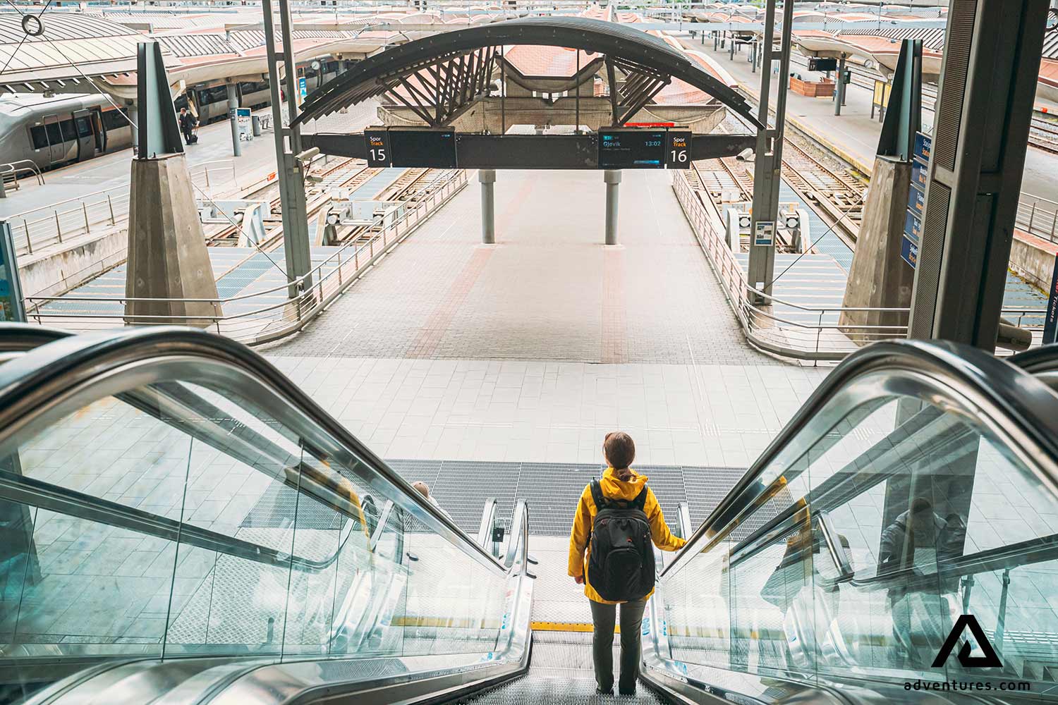 woman walking down an escalator stairs in oslo