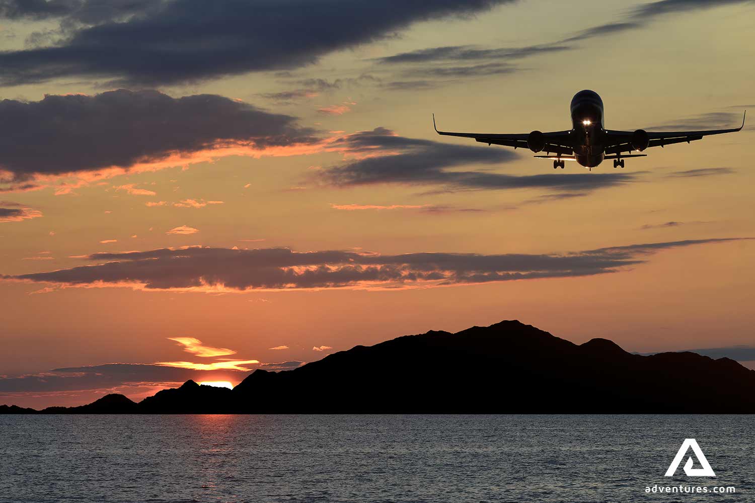 plane landing at a sunset at a fjord in alesund